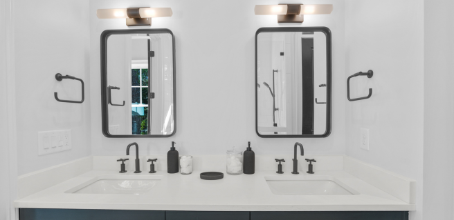 bathroom double vanity with two mirrors and white countertop in River Bluffs community